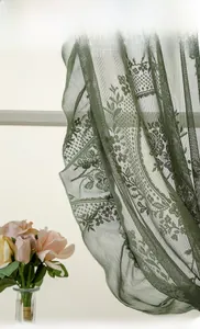 Detail of sage green lace curtain with floral embroidery and elegant scalloped edges