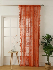 Detail of orange french lace curtain with vintage floral pattern and ruffled edges
