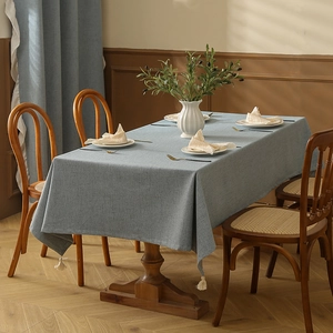 Detail von hellblauer Leinentischdecke mit gewebter Textur und Baumwollquasten
