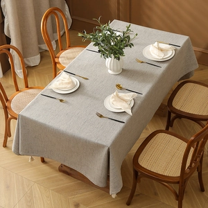 Leinentextur Tischdecke mit eleganten weißen Quasten auf einem Esstisch aus Holz