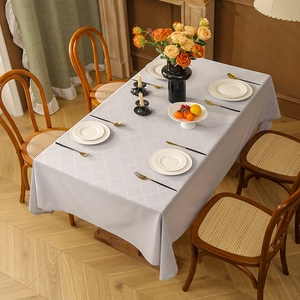 Minimalist light blue rectangle tablecloth with diamond jacquard on a wooden dining table