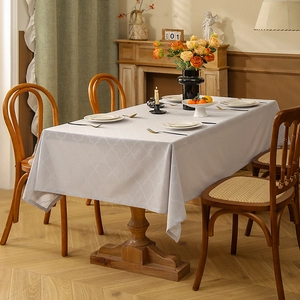 Light gray non-slip tablecloth with geometric jacquard pattern on a rectangular wooden table