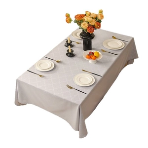 Light gray rectangle polyester tablecloth with white geometric trellis pattern on a dining table