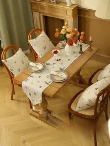 Detailed close-up of wheat embroidery on linen table runner with elegant white tassels