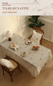Detailed embroidery of pineapple patterns on linen tablecloth with white fringe tassels