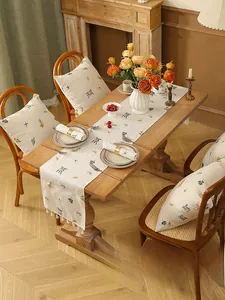 Close-up of linen table runner with wheat embroidery and elegant white tassel edges