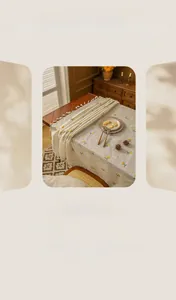 Close-up of linen tablecloth featuring yellow floral patterns and white fringe edge