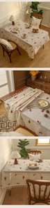 Close-up of red pineapple embroidery and fringe tassel detail on linen tablecloth