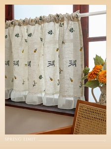Detail of floral embroidery and sheer lace hem on linen Japanese cafe curtain