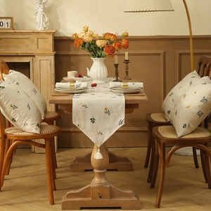 Detailed wheat spike embroidery and linen texture on a rustic runner with tassels