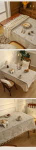 Detailed texture of cotton linen tablecloth with yellow floral embroidery and white tassels