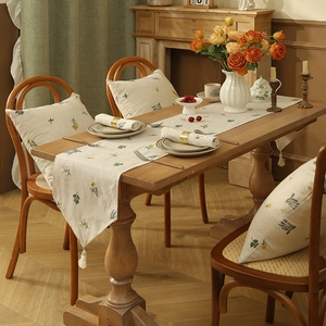 Linen table runner with floral embroidery and tassels for rustic dining decor