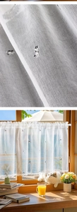 Close-up of linen cafe curtain with cat embroidery and delicate white pom-pom trim