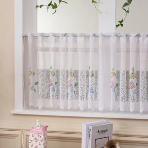 Detailed close-up of white lace cafe curtain with colorful floral embroidery and rod pocket