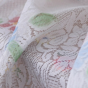 Macro shot of white lace coffee curtain fabric featuring soft pink floral embroidery
