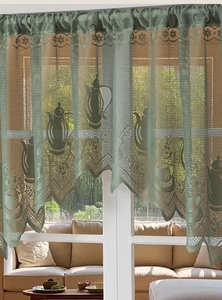 Detail of light green French lace cafe curtain with vintage coffee pot and floral embroidery