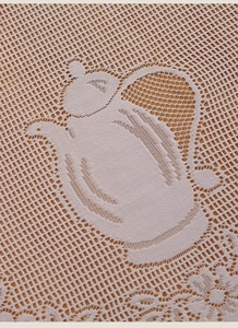 Detail of white lace curtain fabric featuring intricate teapot pattern and mesh structure