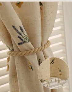 Detail of linen curtain with exquisite lavender embroidery and white thread tassels
