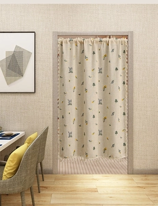 Detail of linen door curtain with wheat embroidery, floral patterns and fringe edges