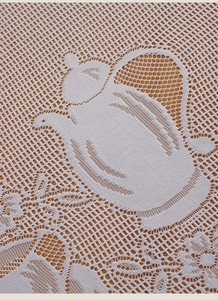 Detailed view of white French lace cafe curtain with teapot patterns and floral mesh