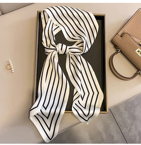 Close-up of elegant black and white striped silk scarf tied as a bow on a luxury tray