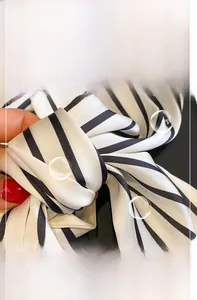 Close-up of soft black and white striped silk scarf showing fine fabric texture and stitching
