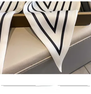 Macro shot of striped silk-feel scarf with geometric V-pattern on white background