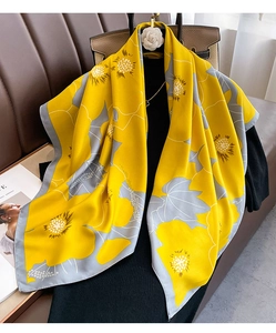 Detail of high-quality silk scarf with yellow floral sunflower print on an elegant hanger