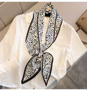 Dettaglio di un foulard in seta con stampa camelia annodato alla francese su una camicia