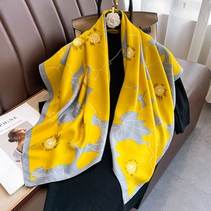 Detailed view of yellow and grey floral silk scarf with premium satin finish on black top
