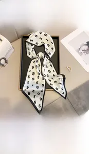 Détail d'un foulard en soie blanche avec imprimé numéroté noir sur plateau décoratif