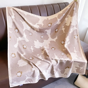 Close-up of floral print silk scarf with Nordic poppy pattern on leather background