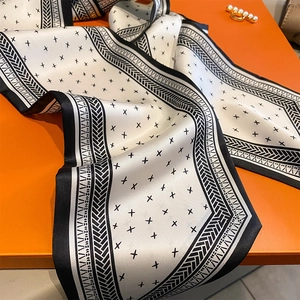 Dettaglio del foulard in seta bianco e nero con bordi a gallone e motivi a stella