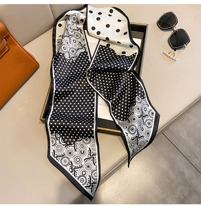 Detail of polka dot silk scarf wrapped on a handbag handle for elegant styling