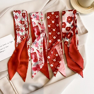 Détails de rubans en soie rouge aux motifs floraux et cœurs sur une veste blazer beige