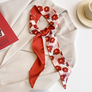 Élégant foulard fin en soie à fleurs rouges noué sur un col de blazer beige