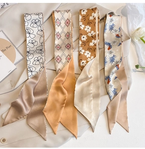 Detailed view of four satin silk scarves in khaki and floral prints on a trench coat