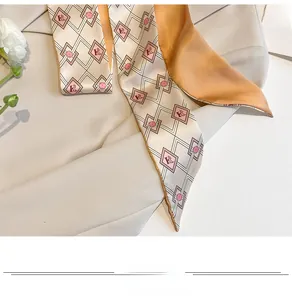 Macro detail of silk skinny scarf with H-letter patterns on a grey blazer lapel