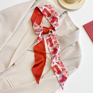 Élégant foulard en soie rouge et blanc avec motif cœur drapé sur blazer beige