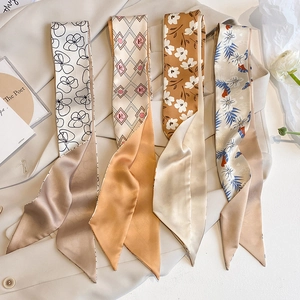 Detail showing various silk twilly scarf patterns on beige blazer for styling