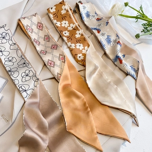 Detailed view of four elegant silk twilly scarves with floral and geometric patterns
