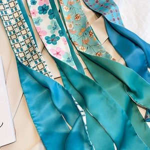 Detailansicht von vier schmalen Twill-Seidenschals mit verschiedenen floralen Mustern