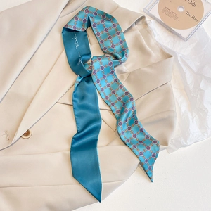 Schmaler Seidenschal mit geometrischem Druck in Blau, gestylt als Krawatte auf Blazer