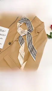 Detail of 7x130cm faux silk twilly scarf with Greek key pattern on a khaki blazer