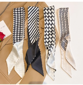 Detailed close-up of four patterned narrow silk scarves styled on a blazer jacket