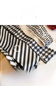 Detailed macro view of narrow silk scarves showing classic patterns and satin texture