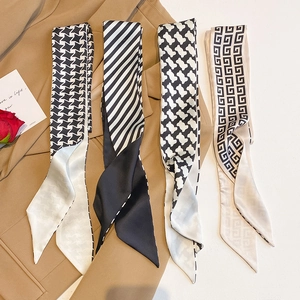Detail of four black and white patterned silk scarves on a blazer, showing premium textures