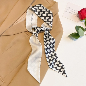 Elegant black and white skinny silk scarf with bear print styled on a beige blazer lapel