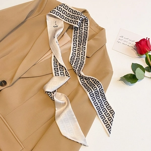 Narrow satin twilly scarf with geometric pattern draped over a khaki blazer
