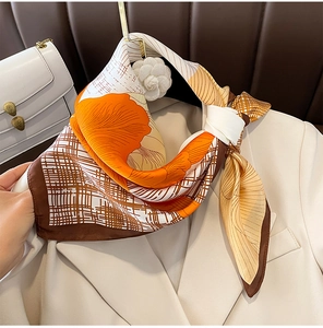 Close-up of floral pattern silk scarf paired with a beige blazer in a lifestyle setting
